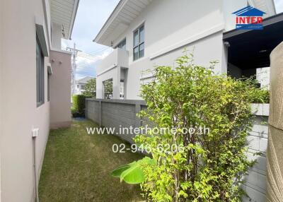 Photo of the exterior pathway between buildings with grass and plants