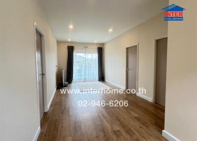 Spacious living area with wooden flooring and natural light