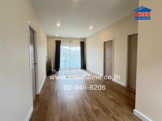 Spacious living area with wooden flooring and natural light