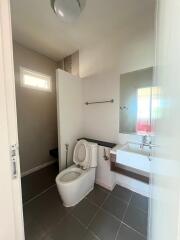 Bathroom with toilet, sink, and tile flooring