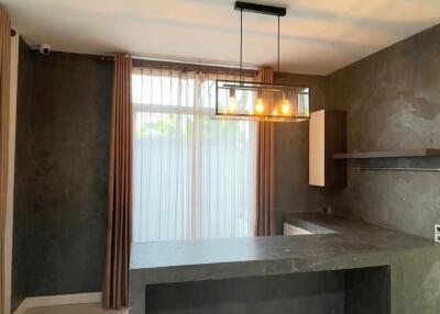 modern minimalist kitchen with dark countertops and hanging light fixture