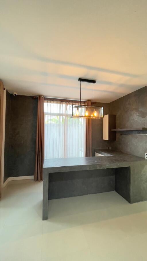 modern minimalist kitchen with dark countertops and hanging light fixture