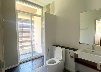 Modern bathroom with toilet, sink, and large window