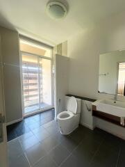 Modern bathroom with toilet, sink, and large window