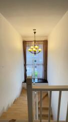 Staircase with large window and chandelier