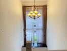 Staircase with large window and chandelier