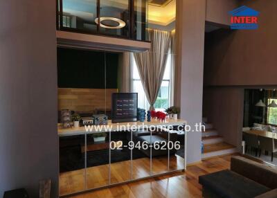 Modern living area and kitchen with wooden flooring and mirrors