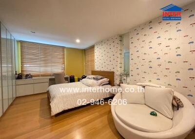 Modern bedroom with double bed, sofa, and work desk