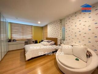 Modern bedroom with double bed, sofa, and work desk