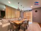 Modern dining area with wooden table, white sofa, and pendant lights