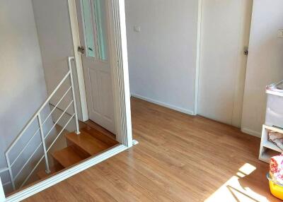 Bright and clean hallway with stair access and wooden flooring