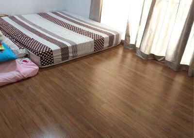 Simple bedroom with wooden flooring and a mattress on the floor