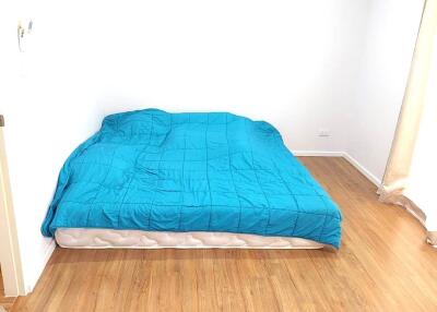 Minimalist bedroom with blue comforter on mattress