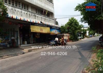 Street view of a building with shops and a sidewalk