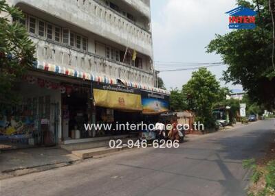 Exterior view of a building with shops and road