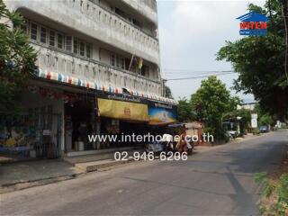 Exterior view of a building with shops and road