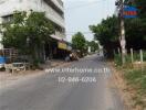 Street view of a building with nearby shops and trees