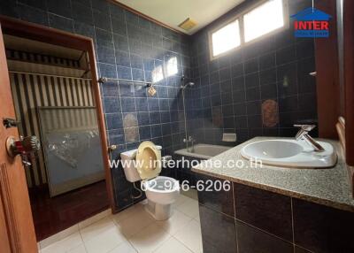 Bathroom with dark tiles and a shower area