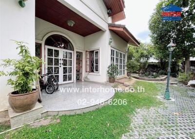 Outdoor view of a house entrance with potted plants and bicycle