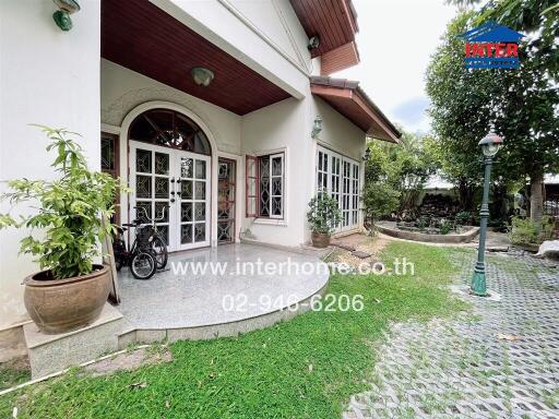 Outdoor view of a house entrance with potted plants and bicycle