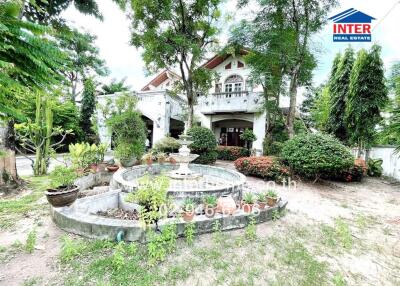 Front view of a residential property with garden and fountain