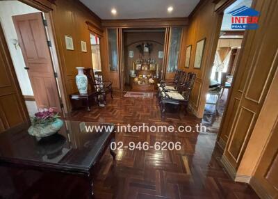 Spacious traditional living room with wooden paneling and flooring