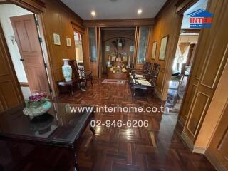 Spacious traditional living room with wooden paneling and flooring