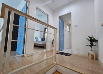 A modern hallway with blue doors leading to various rooms