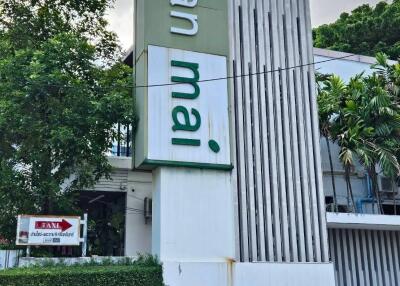 Exterior view of Baan Mai building with surrounding greenery