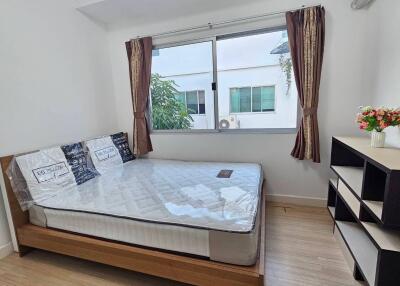 Bedroom with large window, bed, and shelving unit