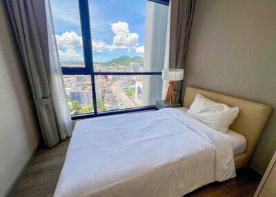 Bedroom with a large window and city view