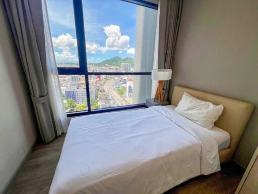 Bedroom with a large window and city view