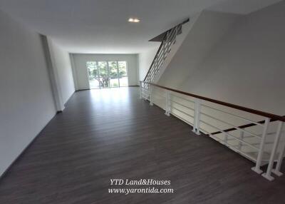 Spacious living area with large windows and staircase