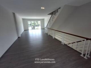 Spacious living area with large windows and staircase