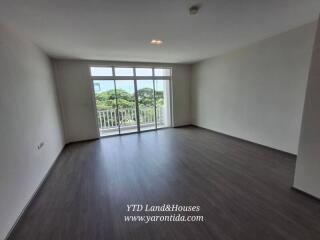 Spacious living room with large windows and balcony