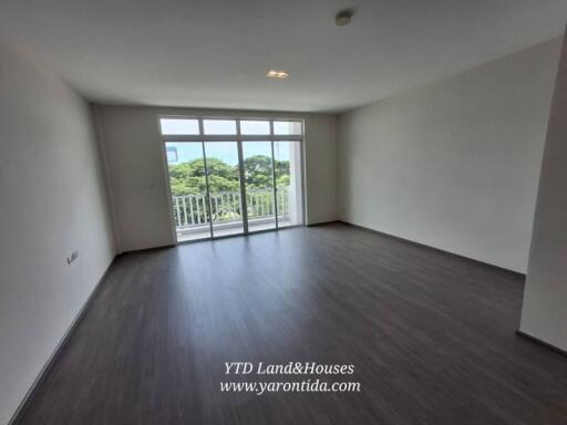 Spacious living room with large windows and balcony