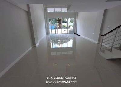 Spacious living room with large windows and staircase