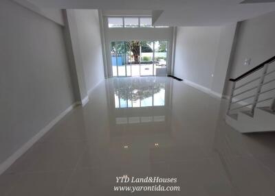 Spacious living area with large windows and staircase