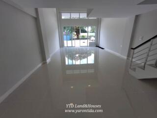 Spacious living area with large windows and staircase