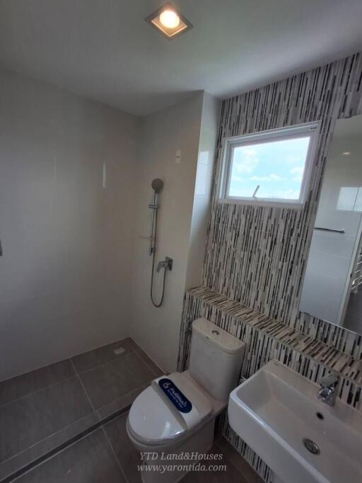 Modern bathroom with shower area, toilet, and sink