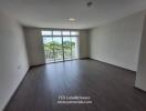 Spacious living room with large window and balcony