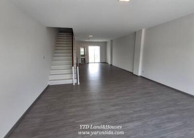 Spacious living area with staircase and large windows