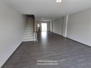 Spacious living area with staircase and large windows