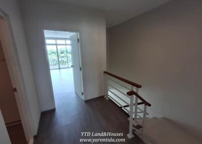 Bright hallway with adjacent rooms and railing