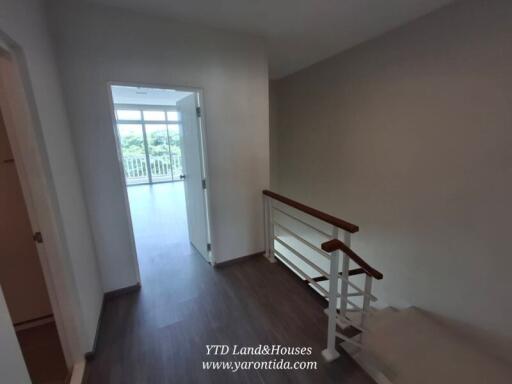 Bright hallway with adjacent rooms and railing