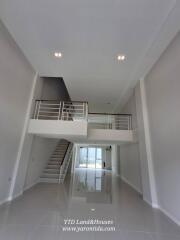 A spacious modern living area with high ceiling and mezzanine