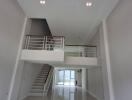 A spacious modern living area with high ceiling and mezzanine