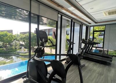 modern gym with exercise equipment and pool view