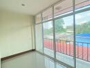 Empty room with large windows and a balcony view