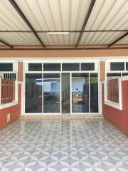 Covered patio area with tile flooring and sliding glass doors